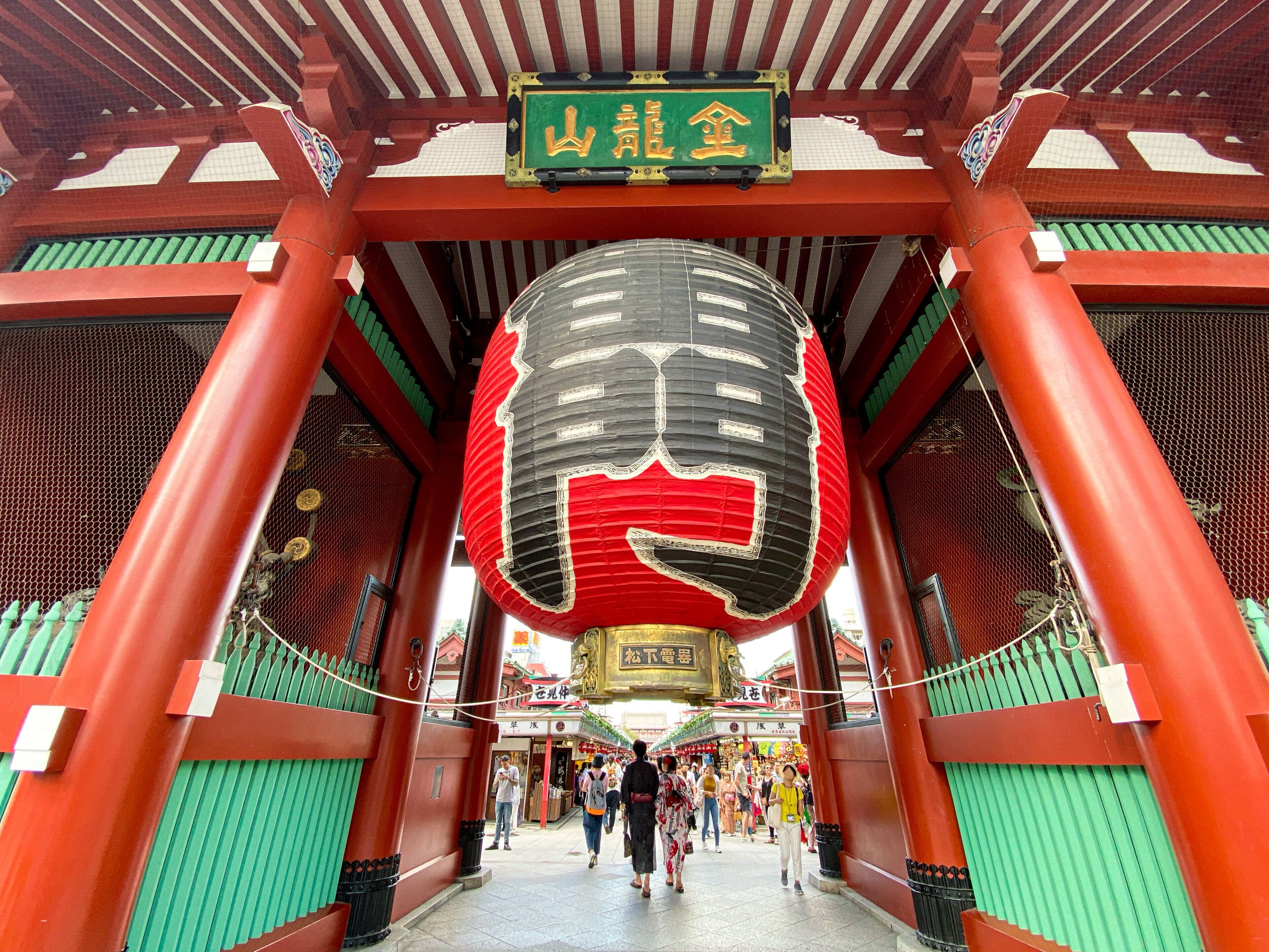 A traditional Japanese torii gate with a large lantern hanging above.