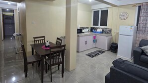 A compact living space with a dining area, kitchenette, and a sofa. - Barefoot Apartments (Roseau)