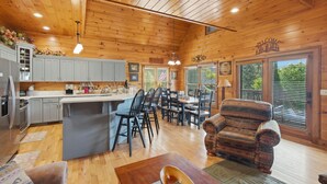 L’intérieur d’un chalet en bois comprend une cuisine, un coin repas et un salon.