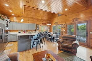 A wooden cabin interior with a kitchen, dining area, and living room. - Lazy Bear Retreat - Idilic Mountain Getaway (Blue Ridge)