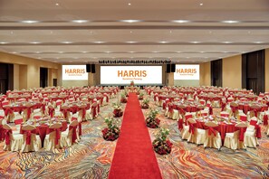 A large conference room with multiple tables arranged in rows, a red carpet leading to the front, and two large screens displaying 'HARRIS Sunshine Penang'. - Harris Hotel & Conventions Sunshine Penang (George Town)