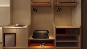 Une petite chambre comprenant une valise, un petit réfrigérateur et un objet en forme de cœur posé sur l’étagère.