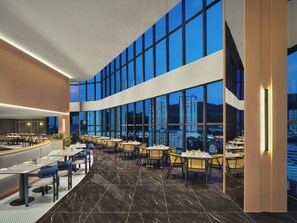 A modern restaurant with a panoramic city view, marble flooring, and contemporary furniture. - Harris Hotel & Conventions Sunshine Penang (George Town)