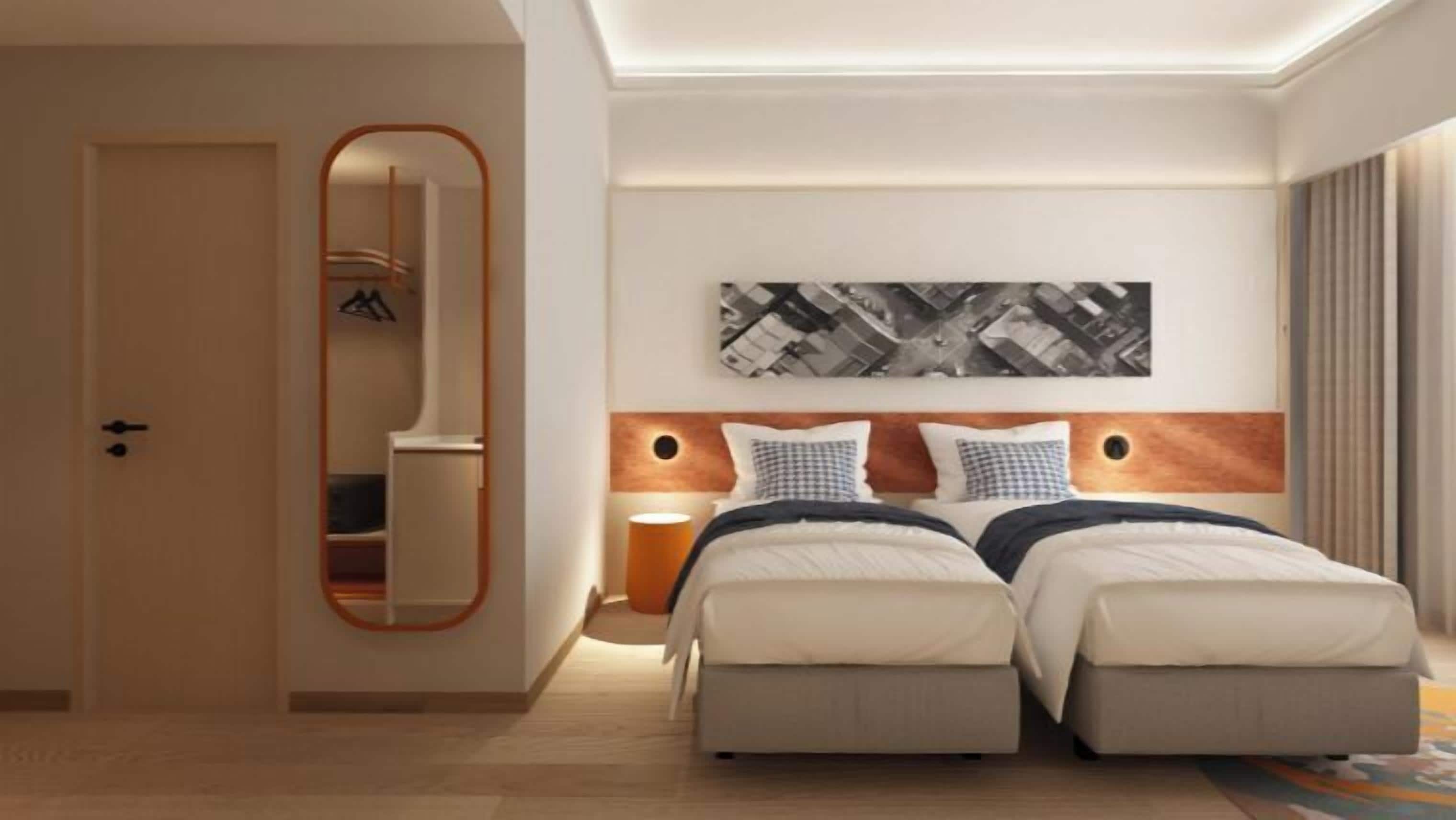 Habitación de hotel con cama doble, espejo, mesita de noche y una obra de arte colgada en la pared.