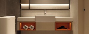 A modern bathroom with a white sink, a mirror, and two shelves with toiletries. - Harris Hotel & Conventions Sunshine Penang (George Town)