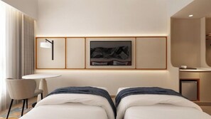 A modern hotel room with a bed, a desk, a chair, and a framed picture on the wall.