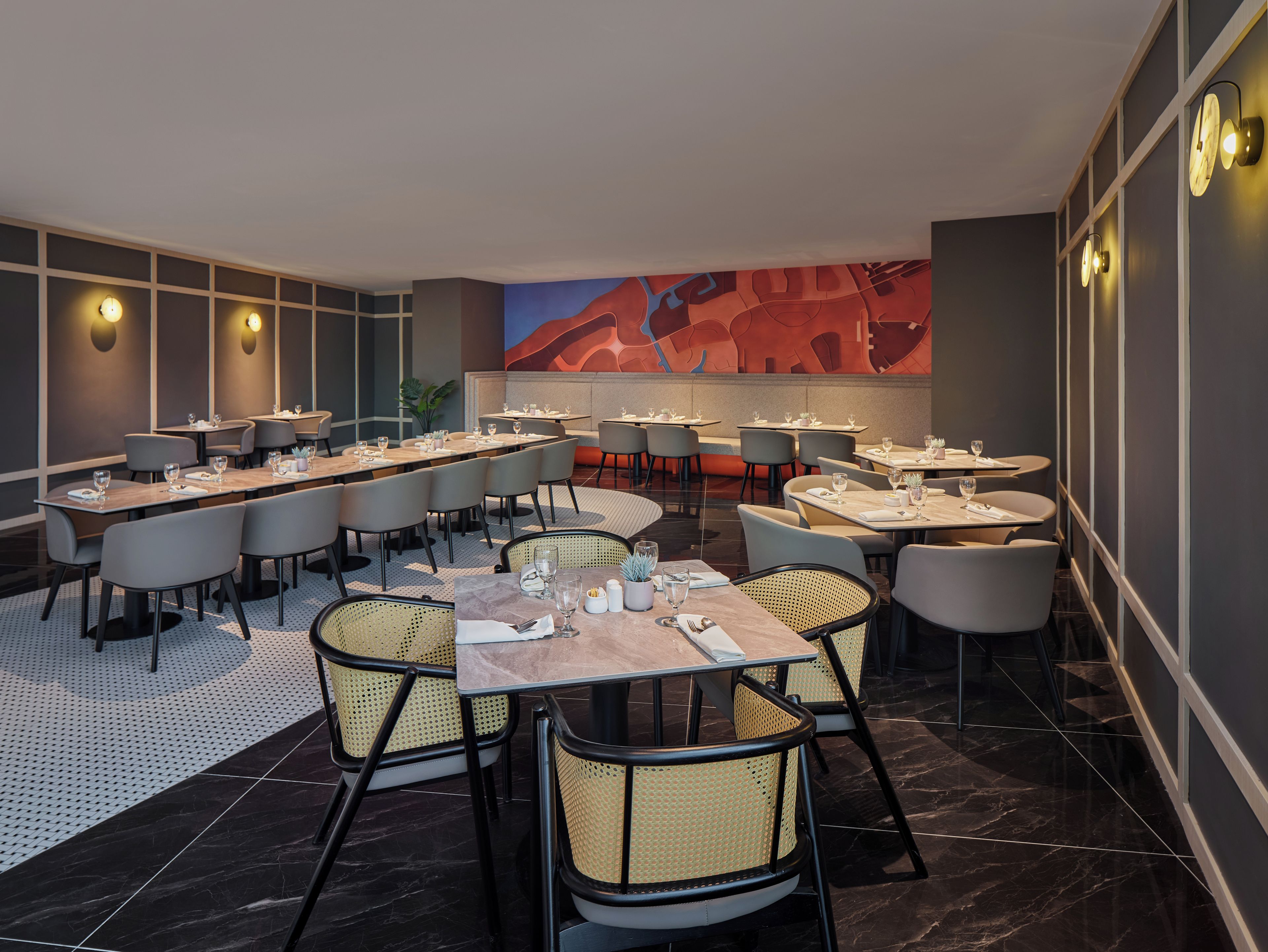 A modern dining area with multiple tables and chairs, a patterned floor, and a large abstract mural on the wall.