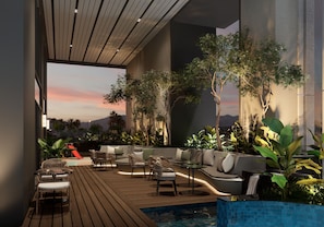 Un espace de détente extérieur moderne, doté de sièges, d’une piscine et offrant une vue sur le coucher de soleil.