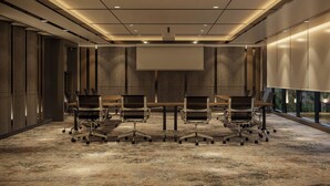 A conference room with a large table, six chairs, a projector screen, and a carpeted floor. - Oakwood Slipi Jakarta (Jakarta)