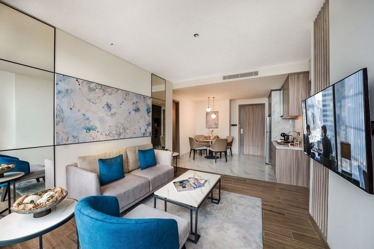 Un salon moderne avec un canapé, une table basse et un coin repas avec des chaises.