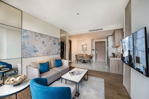 Un salon moderne avec un canapé, une table basse et un coin repas avec des chaises.