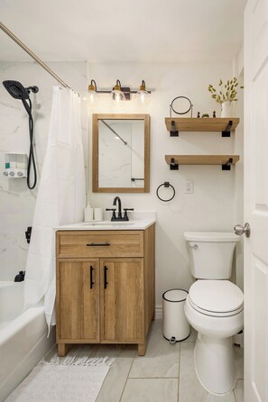 Een haardroger, handdoeken, zeep, toiletpapier