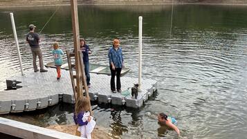 Une jetée s’avançant dans un lac paisible, avec des personnes debout dessus.