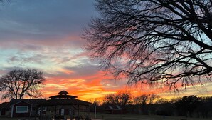 A gazebo with a roof, a lawn, and a building with a red roof in the background. - A little bit of heaven on a fun filled ranch outside quaint Brenham (Brenham)