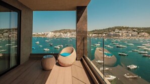 A balcony with a view of a marina and cityscape. - Ushuaia Playa Xemxija Boutique Hotel (St. Paul's Bay)