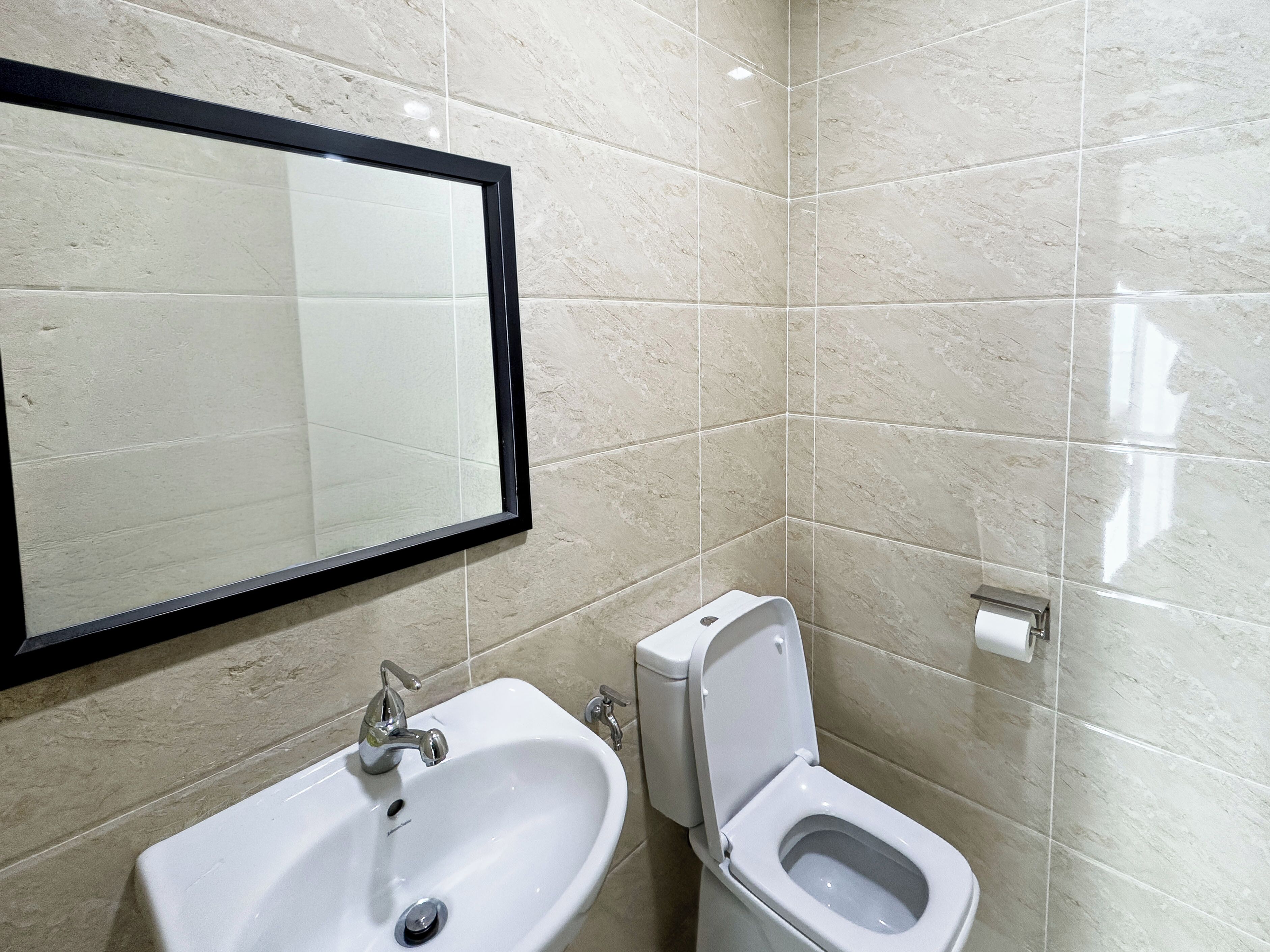 Un baño con lavabo, inodoro y espejo.
