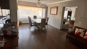 A spacious living area with a dining table, chairs, a sofa, and a kitchen area. - Apartment near Carolina Park (Quito)