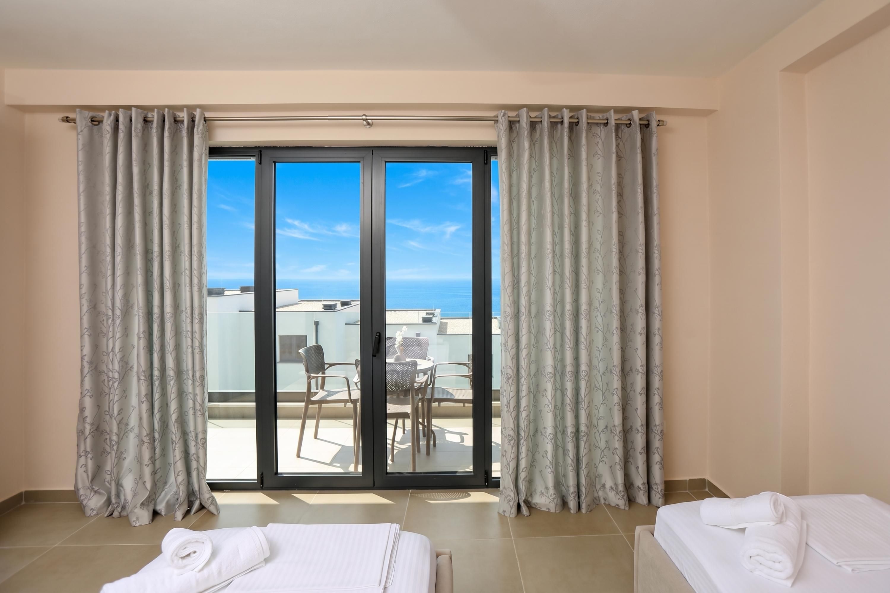 Une chambre d’hôtel avec un balcon, un lit, une chaise et une table.