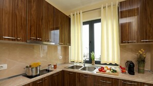 Eine moderne Küche mit Holzausstattung, einem Spültisch und einem Fenster mit Vorhängen.