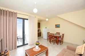 Eine moderne Wohnung mit Essbereich, Küche und Balkon.