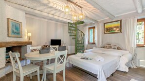 Ein Schlafzimmer mit einem Bett, einem Schreibtisch, einem Stuhl, einem Kamin und einer Treppe.