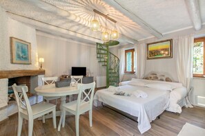 Ein Schlafzimmer mit einem Bett, einem Schreibtisch, einem Stuhl, einem Kamin und einer Treppe.