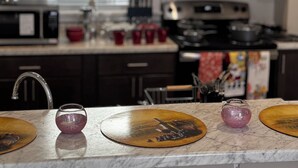A kitchen with a sink, stove, and cabinets.