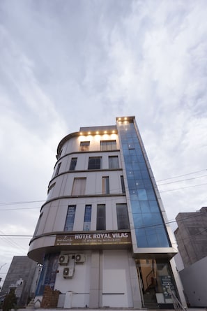 Un hĂŽtel Ă plusieurs Ă©tages, sur lequel on peut lire lâinscription « HĂTEL ROYAL VILAS ».