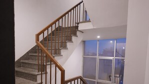 A staircase with wooden railings and granite steps leading to a landing. - Hotel Royal Vilas (Bharatpur)