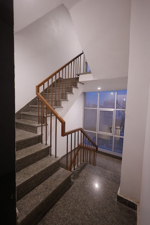 A staircase with wooden railings and granite steps leading to a landing. - Hotel Royal Vilas (Bharatpur)