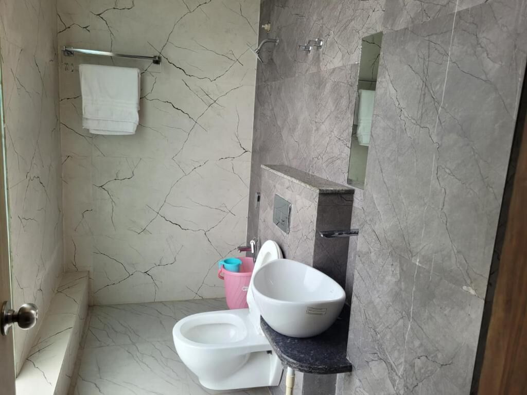 A bathroom with a toilet, sink, and shower area.