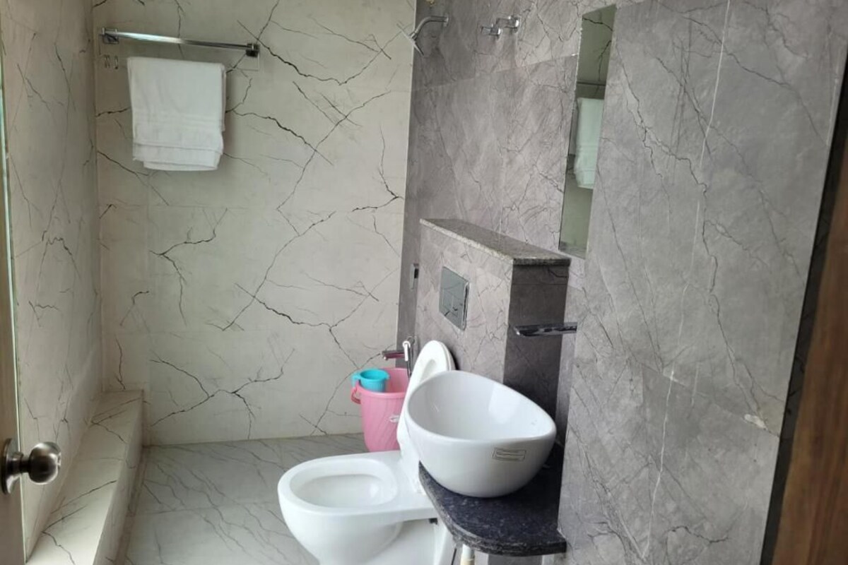 A bathroom with a toilet, sink, and shower area.
