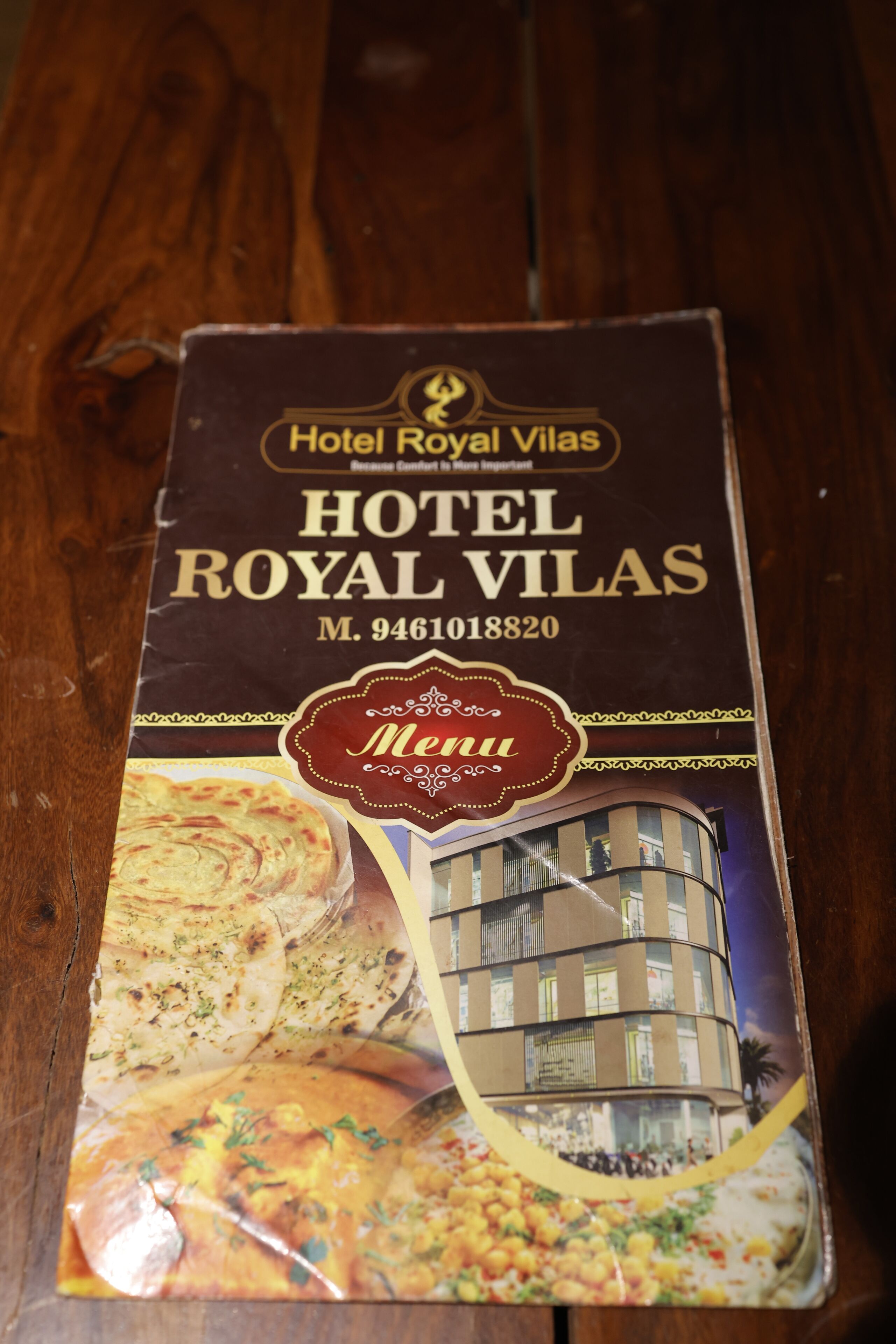 A menu cover for Hotel Royal Vilas with a building image and food items.