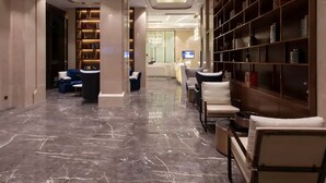 A hotel lobby with marble flooring, seating areas, and bookshelves. - Yeste International Hotel Wuhan Tiandi (Wuhan)
