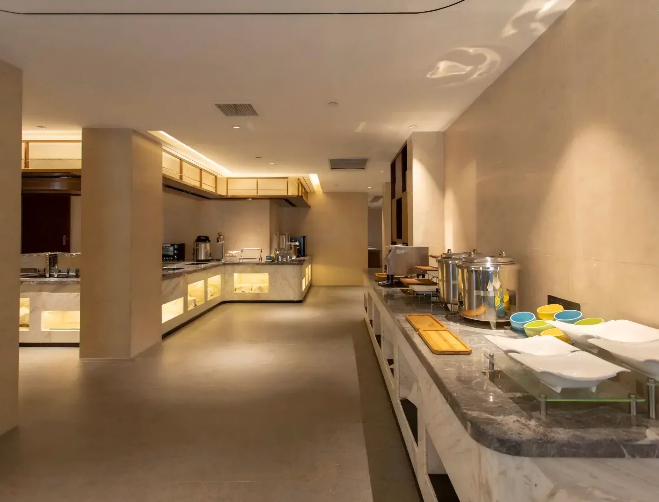 A modern kitchen with marble countertops, built-in appliances, and a central island.