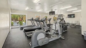 A gym with treadmills, elliptical machines, and a TV screen. - Central Scottsdale Haven Condo (Scottsdale)