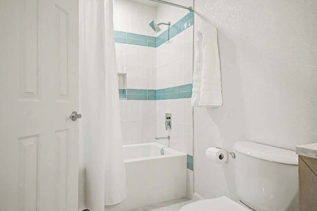 Ein Badezimmer mit Badewanne, Toilette und Duschvorhang.