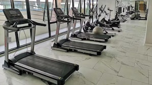 Ett gym med flera löpband, träningsbollar och styrketräningsmaskiner.