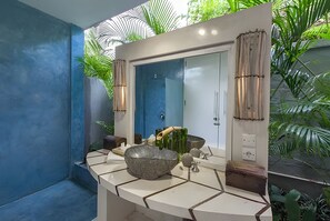 A bathroom with a large mirror, a bowl sink, and a shower.