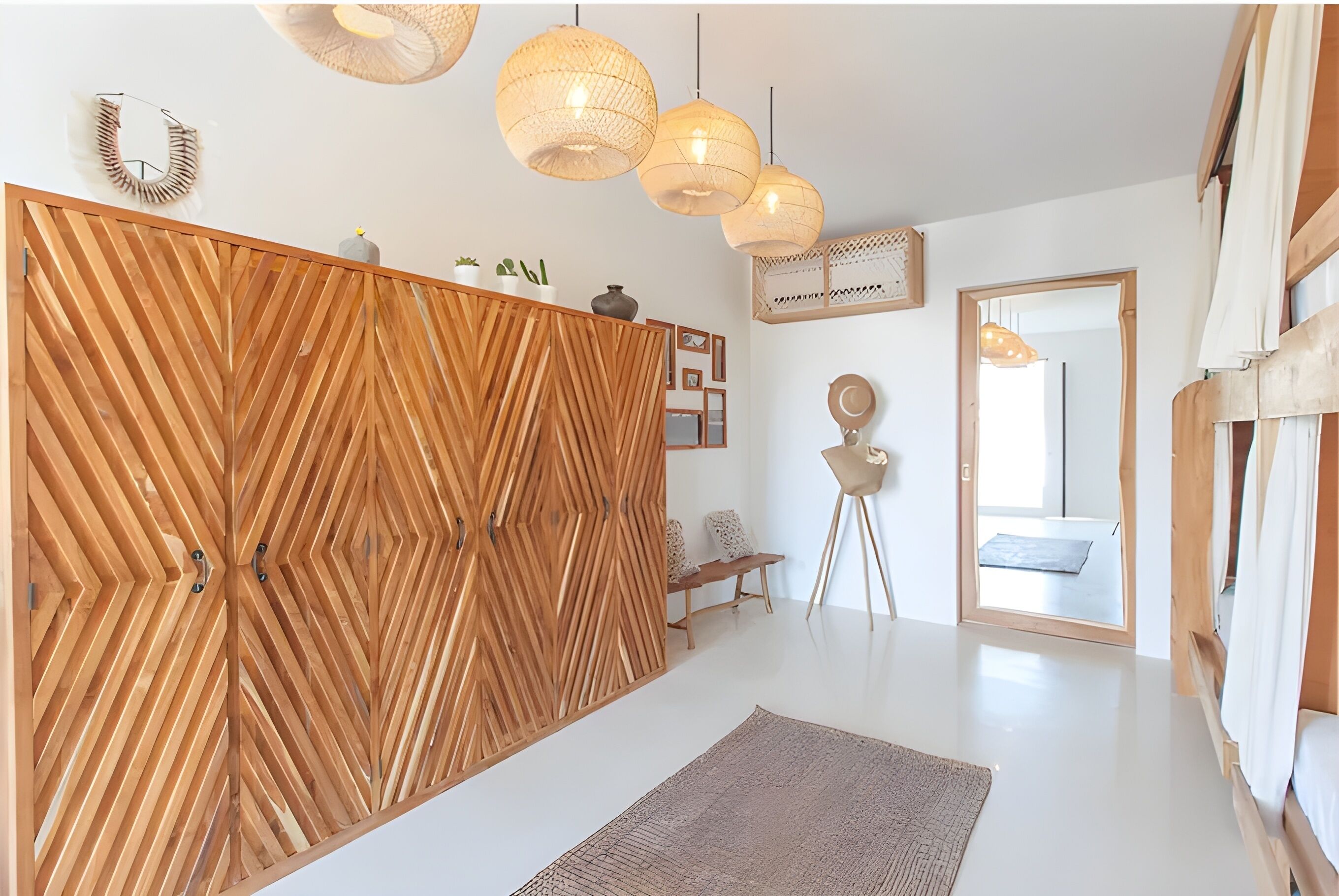 A modern interior with a wooden partition, hanging lights, and a bench.