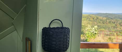 A wall with a house-shaped decoration and a woven basket.