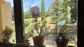 A window with a view of a garden, a sink with a faucet, and a bottle of hand soap. - Villa and Annex House with Pool   InBorgo (MONTECASTRILLI)