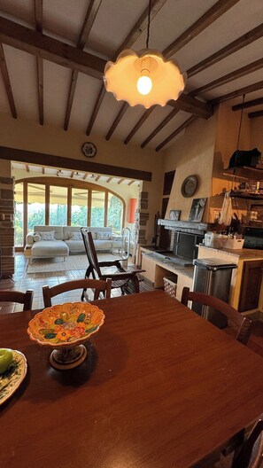 A dining area with a wooden table, chairs, and a decorative bowl. - Magical Umbrian Villa and Guest House with Pool (MONTECASTRILLI)