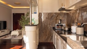 Uma cozinha moderna com painel de mármore, eletrodomésticos embutidos e uma ilha central.