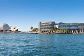 Ein Hotel direkt am Wasser mit modernem Design, ein großes Mehrstöckengebäude mit Balkonen.