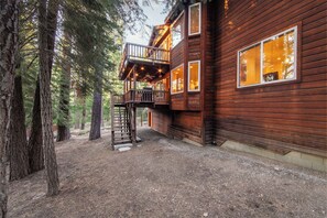 Eine Holzhütte mit Balkon, umgeben von Bäumen.