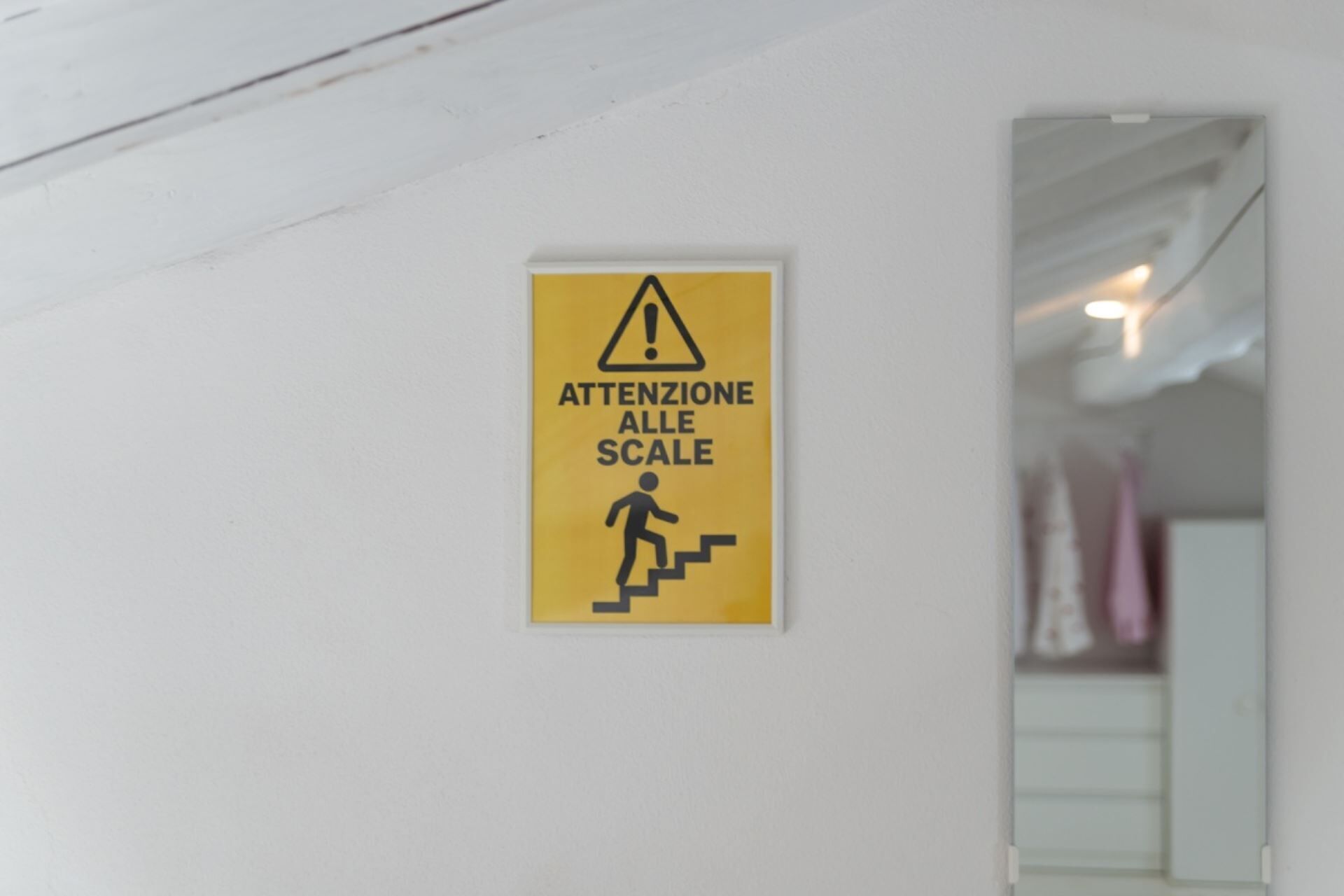 A caution sign with a figure climbing stairs, warning of a change in floor level.