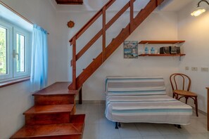 Una scala conduce a una camera da letto con un letto e una sedia.