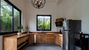 A modern kitchen with wooden cabinets, a stainless steel refrigerator, a built-in oven, a sink, and a large window overlooking a garden. - Orfeas Villas 1 - Luxury 2BR Canggu Private Pool, Rooftop Lounge (Kabupaten Badung)