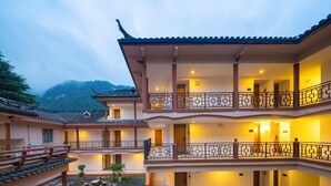A multi-story hotel with balconies, a courtyard, and traditional architecture. - Tianchong Yunhai Courtyard Hotel (Zhangjiajie)